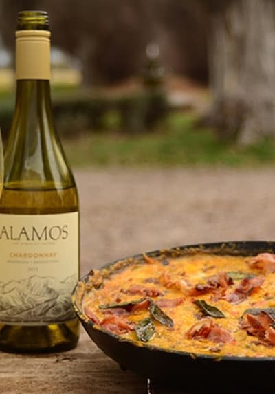 Een fles Alamos met een pan paella ernaast
